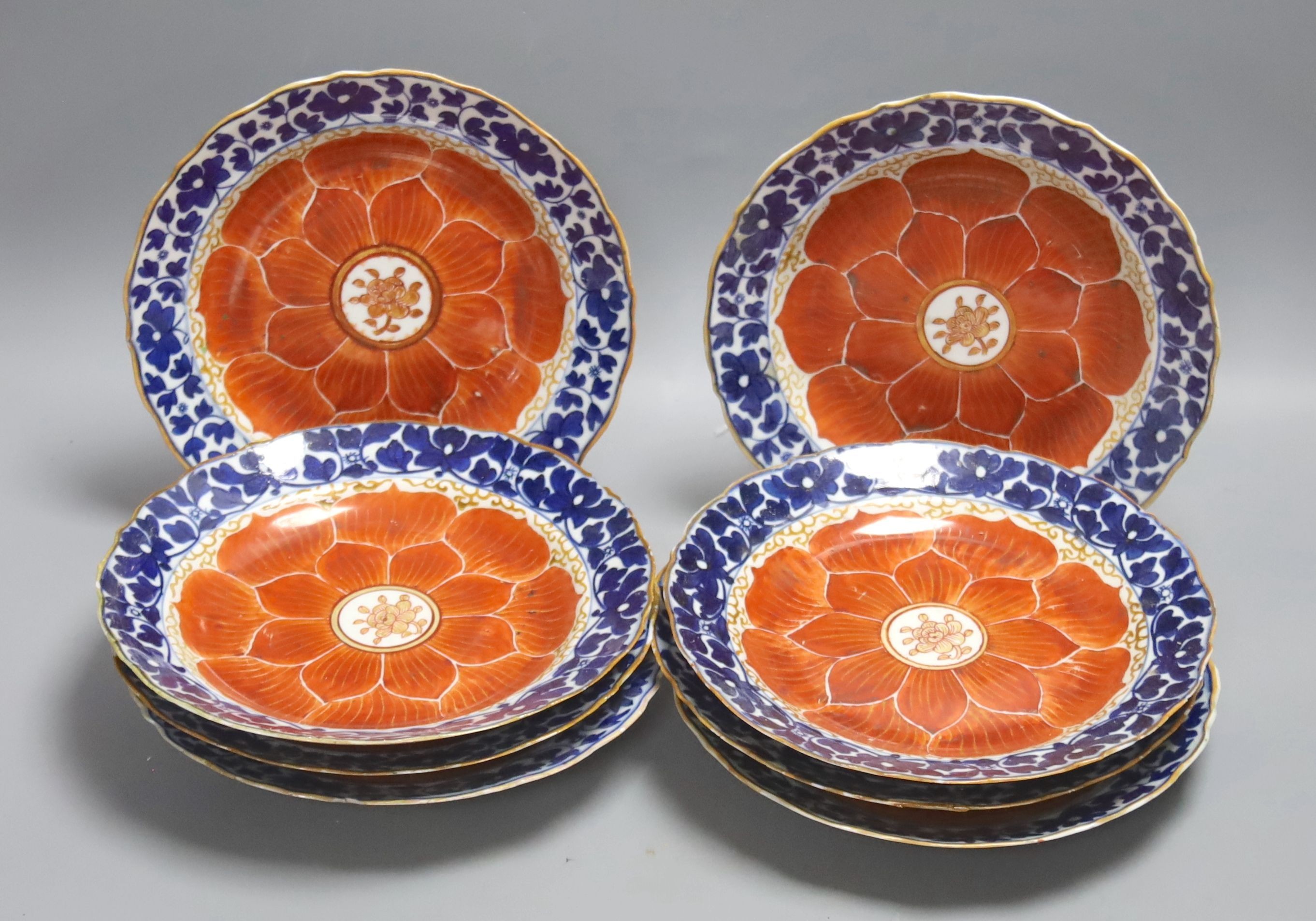 A set of eight Chinese plates with orange 'lotus' centres and blue floral borders, Qing dynasty, Dia 20cm